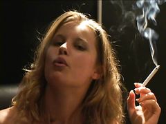 Курящая девушка раздевается и рассматривает красивое тело