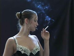 Курящая девушка раздевается и рассматривает красивое тело